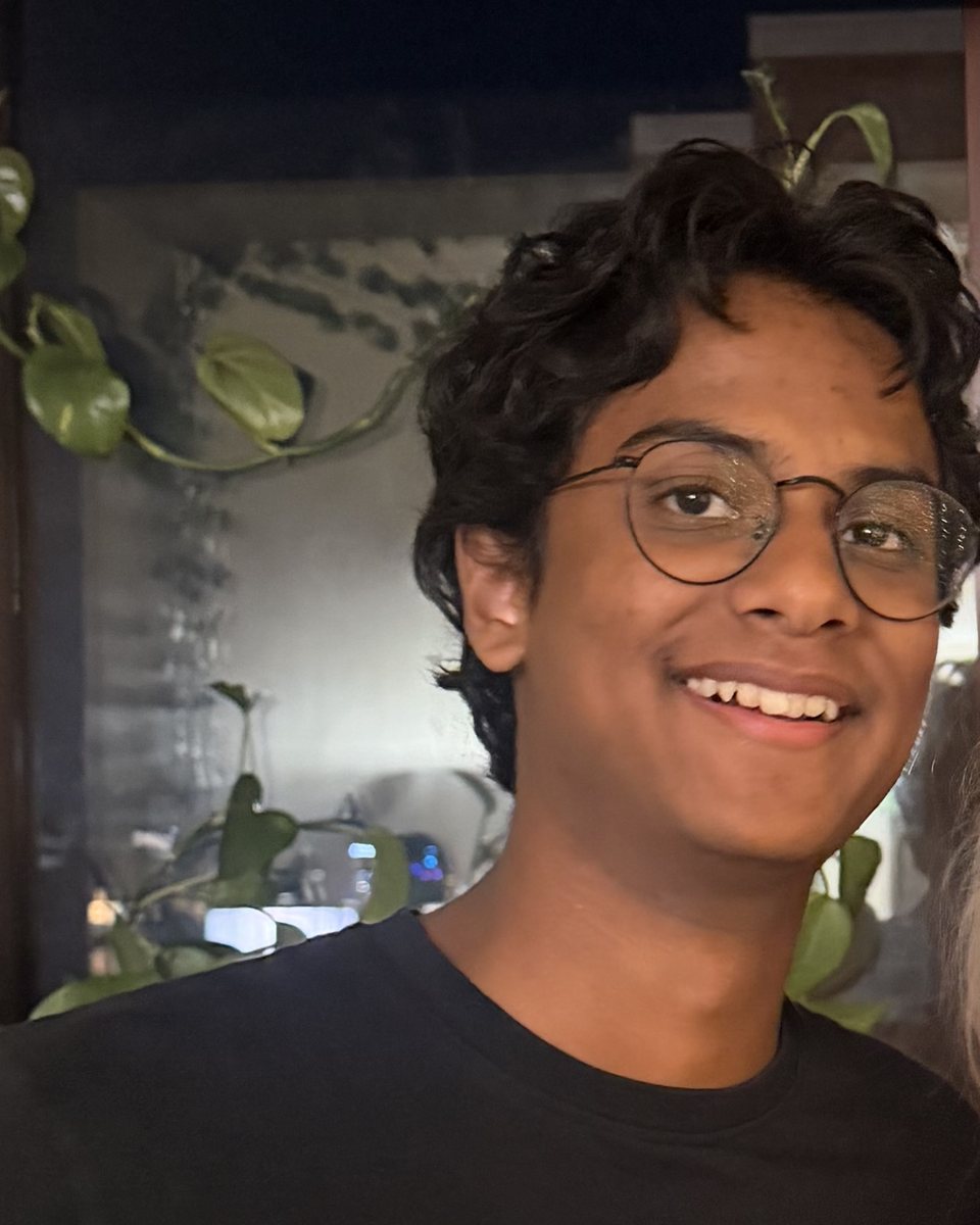 Vedant Rakhonde, smiling, in round wire glasses